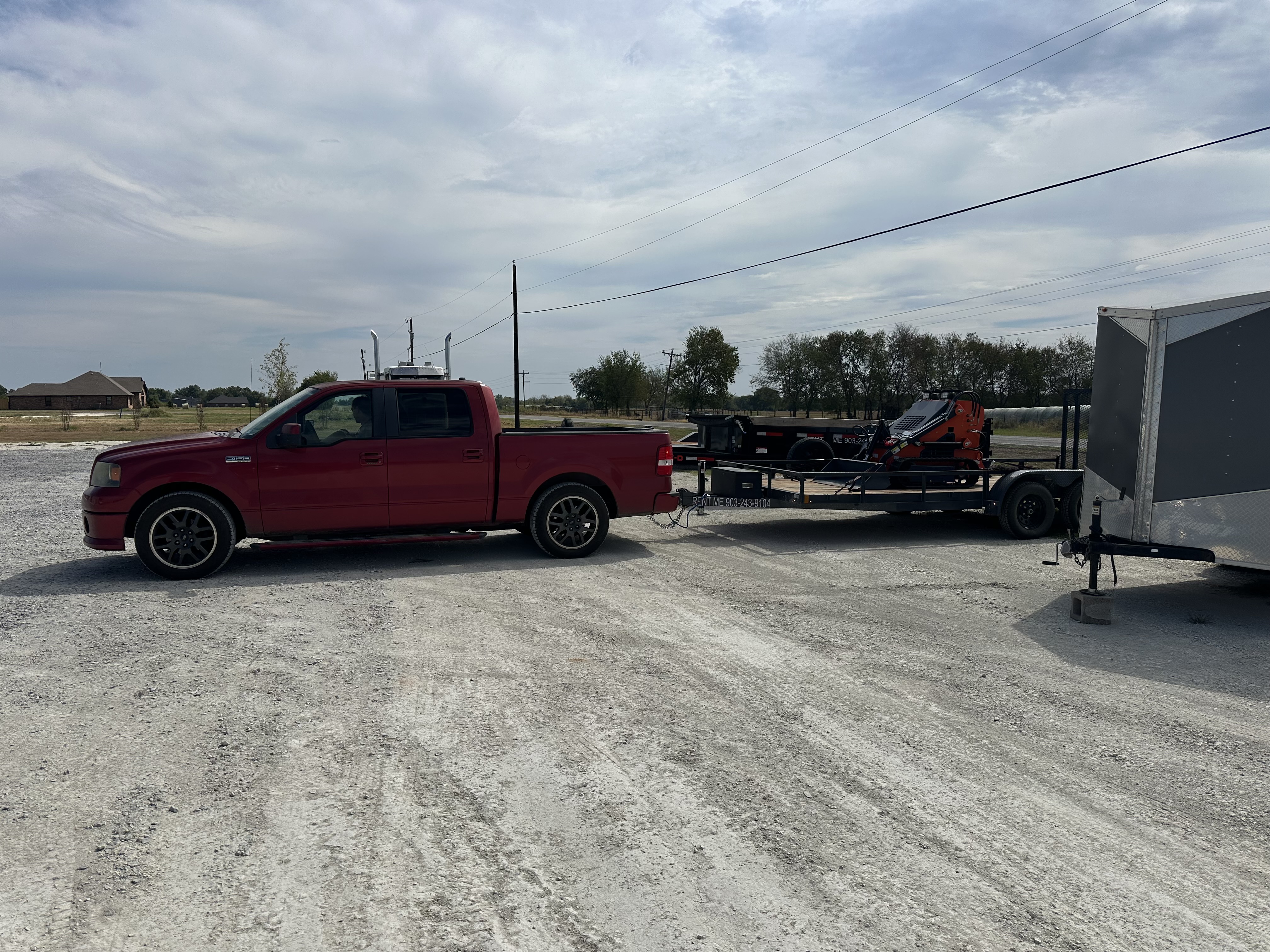 Ford F-150 towing the mini skid steer on its trailer